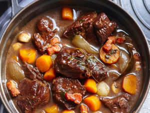 Qu'est-ce que le bœuf bourguignon ? Un plat traditionnel français de bœuf mijoté dans une sauce au vin rouge, avec des petits oignons, des champignons de Paris et des lardons au bacon. Il porte traditionnellement le nom de la région de Bourgogne en France, d'où il est originaire. Il est cuit jusqu'à ce que la viande s'effondre et que la sauce riche en vin épaississe légèrement pour enrober la viande. C'est un plat réconfortant à cuisson lente, parfait pour la purée de pommes de terre, la polenta molle ou simplement du pain croustillant pour éponger la sauce. Le secret de cette riche casserole de bœuf est d'utiliser tout le vin et pas de bouillon. Notre recette ultime de bœuf bourguignon est un classique réconfortant instantané, plein de saveurs satisfaisantes.