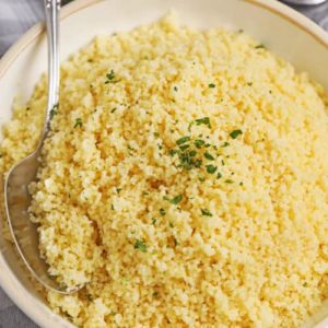 Le couscous est fabriqué à partir de petites boules de farine de semoule cuites à la vapeur. Bien que nous le considérions comme un grain, il s'agit en fait d'un type de pâtes. Le couscous est un plat nord-africain composé de petites boules de farine de semoule cuites à la vapeur. Bien que nous le considérions et le cuisinions comme un grain, le couscous est en fait un type de pâtes. C'est l'un des plats d'accompagnement les plus faciles, les plus rapides et les plus polyvalents que vous puissiez préparer. Et c'est particulièrement merveilleux avec des ragoûts ou des plats principaux en sauce. Selon la marque que vous achetez, vous constaterez qu'il existe des variations dans les proportions suggérées de liquide par rapport au couscous.