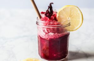 La boisson à l'hibiscus (jus d'hibiscus) ou Roselle Drink est une boisson à base de plantes à base de fleurs de roselle séchées. Il offre une belle teinte cramoisie, présente plusieurs avantages pour la santé et est très facile à préparer. Rafraîchissante et sucrée, cette boisson est idéale pour l'été, les dîners, les rencontres et les fêtes.